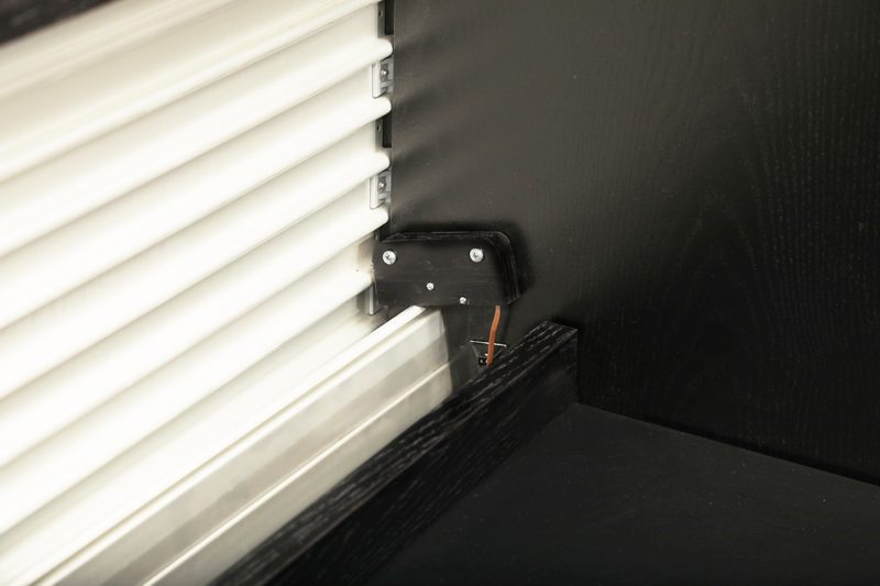 Ascension 1472 lift desk safety switch detail below the anodized tambour