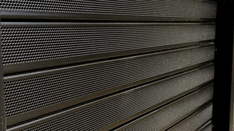 Perforated powder coated tambours closed and locked on an equipment rack