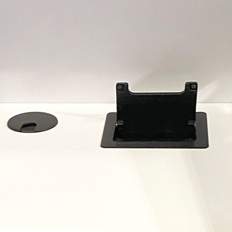 Technology port grommet and outlet shown on a desk worksurface